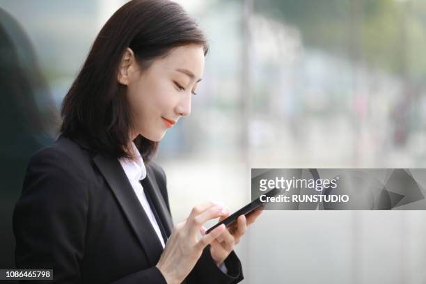 businesswoman using smartphone outdoors - ビジネスウーマン　日本 ストックフォトと画像