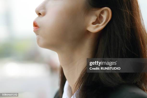 close up of woman blowing out mouth - human mouth stockfoto's en -beelden