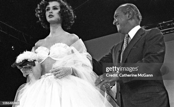 Oscar De La Renta and model on runway after a show of his fashions in the mid 1990s in New York City, New York.