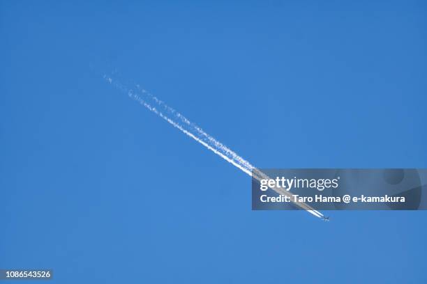 the flying airplane and vapor trail in the blue sky in japan - sunset with jet contrails stock pictures, royalty-free photos & images