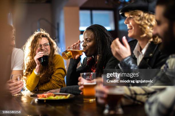 positive atmosphere at pub - crowded bar stock pictures, royalty-free photos & images