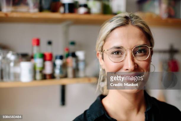 portrait of smiling woman standing in kitchen at home - woman 38 stockfoto's en -beelden