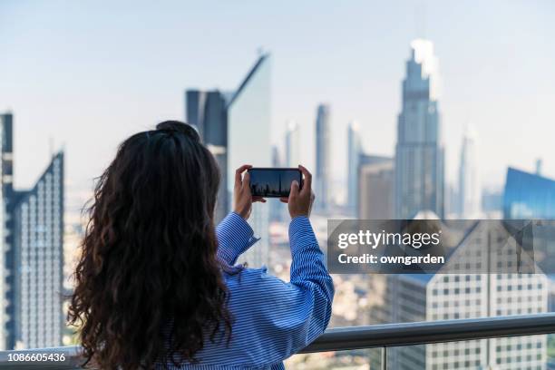 women watching cityscape of dubai with modern futuristic architecture in united arab emirates - dubai tourism stock pictures, royalty-free photos & images