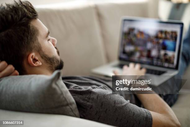 giovane che usa il laptop a casa - downloading foto e immagini stock