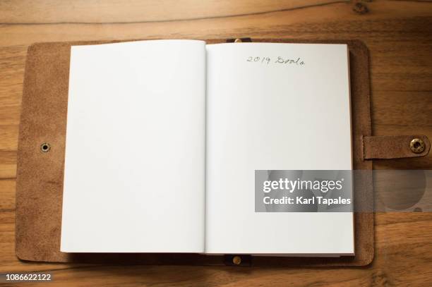 a leather-bound note pad with a short phrase "2019 goals" written on it - leather notebook stock pictures, royalty-free photos & images