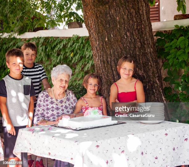 grandchildren and grandmother at birthday celebration - 90 birthday stock pictures, royalty-free photos & images