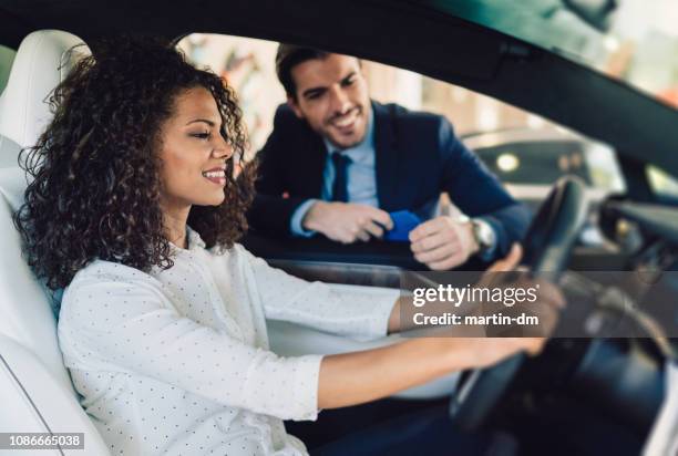 mixed race woman enjoying new car - dealership stock pictures, royalty-free photos & images