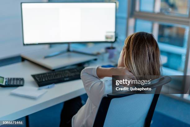businesswoman sitting in a office worried about a problem - neckache stock pictures, royalty-free photos & images