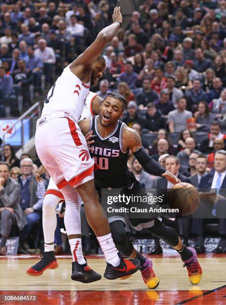 Frank Mason III of the Sacramento Kings drives against C.J. Miles of the Toronto Raptors in an NBA game at Scotiabank Arena on January 22, 2019 in...