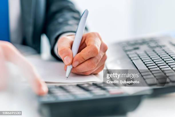 business man using calculator - tax policy stock pictures, royalty-free photos & images