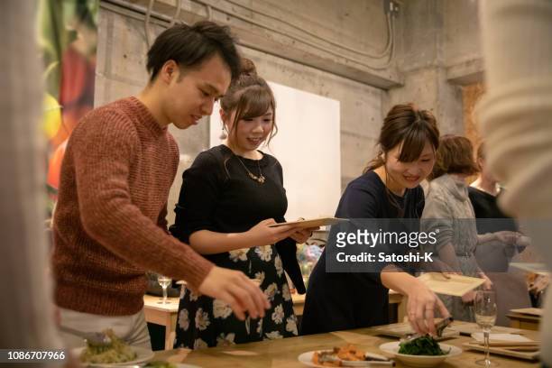 jóvenes, recogiendo alimentos en el partido social - only japanese fotografías e imágenes de stock