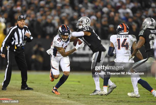 Tim Patrick of the Denver Broncos runs with the ball after catching a pass and gets forced out of bounds by Marcus Gilchrist of the Oakland Raiders...