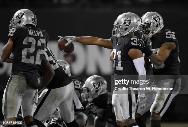 Marcus Gilchrist of the Oakland Raiders and teammates celebrates after Gilchrist intercepted a pass against the Denver Broncos late in the fourth...