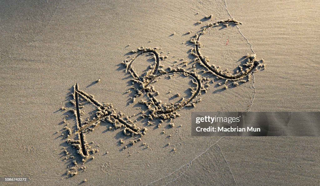 The letters ABC written on sand