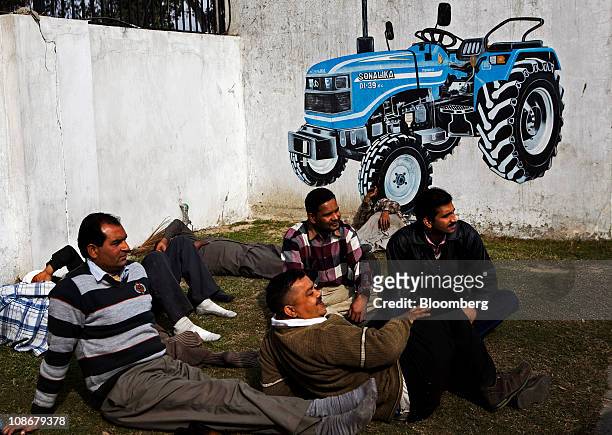 Employees rest on a lawn outside Sonalika Group's International Tractors Ltd. Plant in Hoshiarpur, Punjab, India, on Saturday, Jan. 29, 2011. India's...