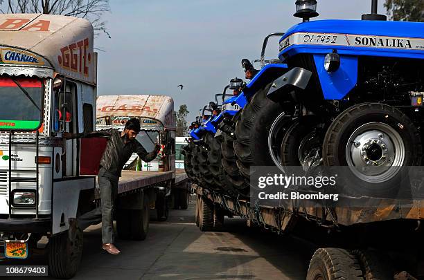 Tractors are loaded on to a truck outside Sonalika Group's International Tractors Ltd. Plant in Hoshiarpur, Punjab, India, on Saturday, Jan. 29,...