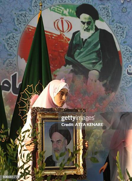 An Iranian woman holds an image of Ayatollah Ruhollah Khomeini during a ceremony marking the 32nd anniversary of his return from exile at Khomeini's...