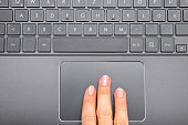 Three fingers of a woman on Notebook Touchpad