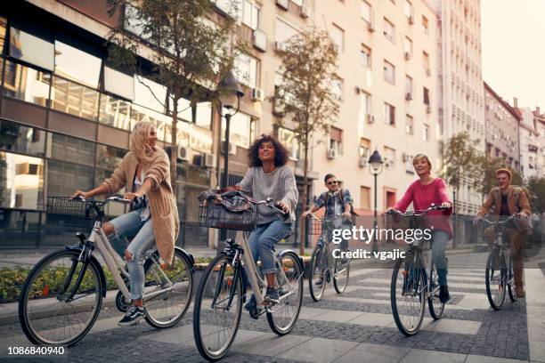 freunde auf fahrrädern in einer stadt - cycling group stock-fotos und bilder