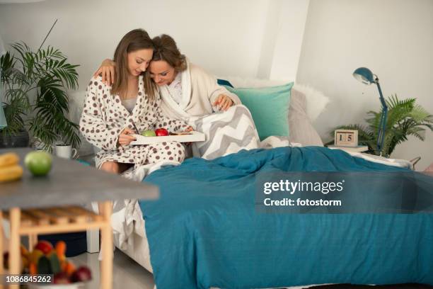 daughter serving breakfast to her mother in bed - mother's day breakfast stock pictures, royalty-free photos & images