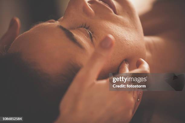 mujer disfrutando el masaje de la cabeza - head massage fotografías e imágenes de stock