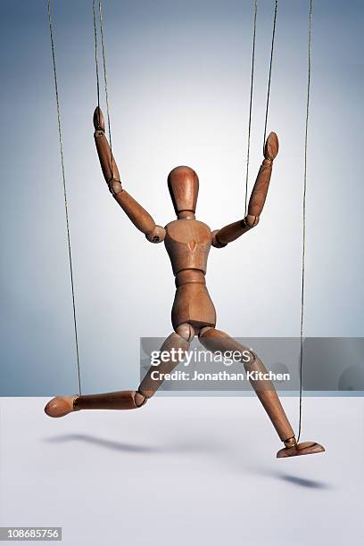 wooden man with strings - puppeteer photos et images de collection