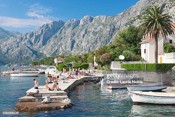 boats moored and people sunbathing, dobrota - kotor bay ストックフォトと画像