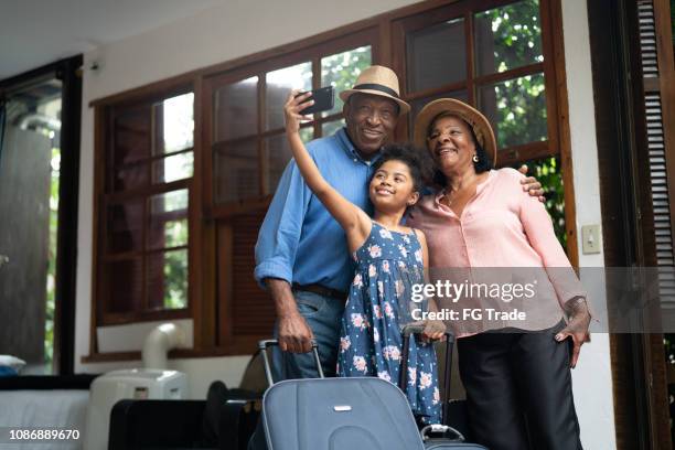 großeltern und enkeltochter unter selfies nach der ankunft in einem hotel - besuch zuhause sommerlich innenaufnahme stock-fotos und bilder