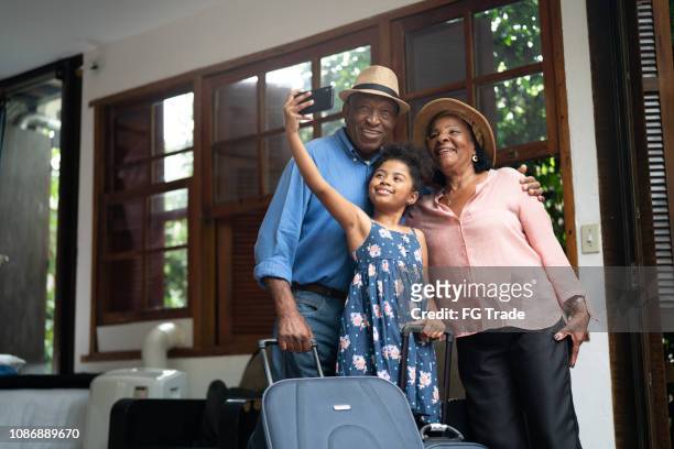 grandparents and granddaughter taking selfies after arriving in a hotel - grandparent phone stock pictures, royalty-free photos & images