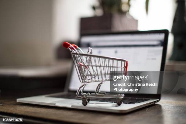 shopping cart on laptop - webshop stockfoto's en -beelden