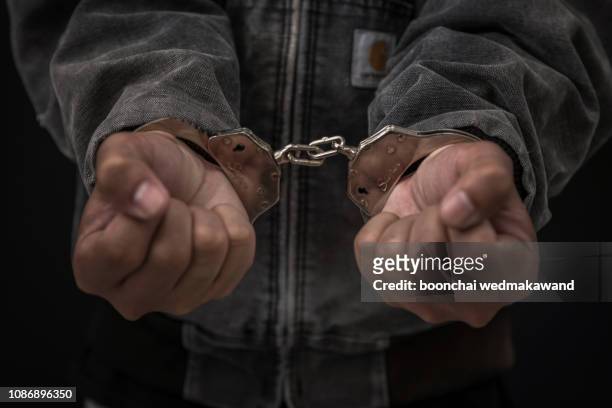upset handcuffed man imprisoned for financial crime, punished for serious fraud - arresto foto e immagini stock