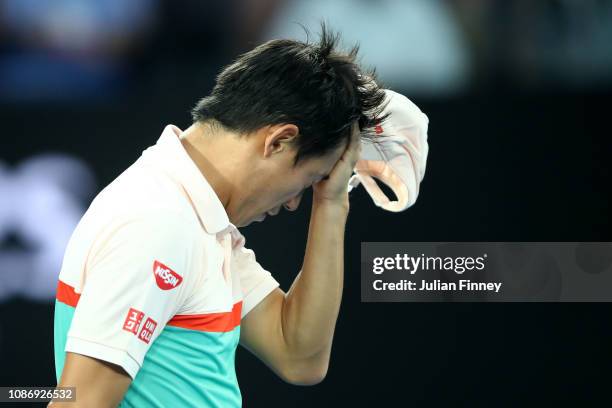 Kei Nishikori of Japan wipes his face after retiring from his quarter final match against Novak Djokovic of Serbia during day 10 of the 2019...