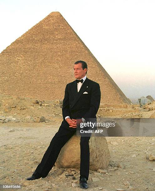 Former secret agent 007 Roger Moore poses in front of Cheops, the largest of Egypt's three Pyramids on the Giza plateau south of Cairo, 2 July 1999....