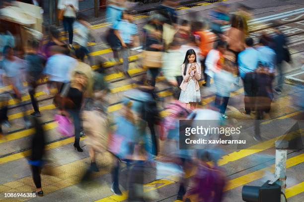 在人群中使用手機的女商人 - hong kong street 個照片及圖片檔