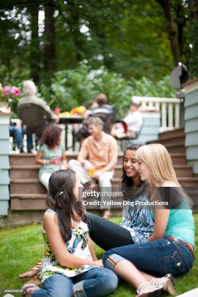 Teen girls talking at neighborhood barbecue