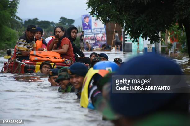 Indonesian soldiers evacuate flood-affected residents in Makassar on January 23, 2019. - At least eight people have been killed and thousands forced...