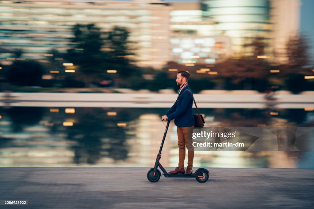 Homme d’affaires, ils utilisent une trottinette dans la ville