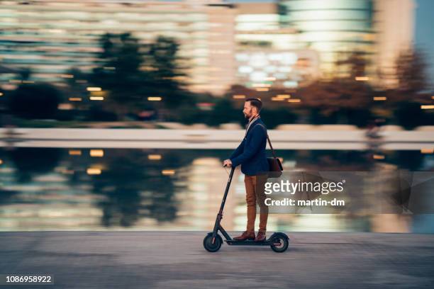 homme d’affaires, ils utilisent une trottinette dans la ville - mobility scooter photos et images de collection