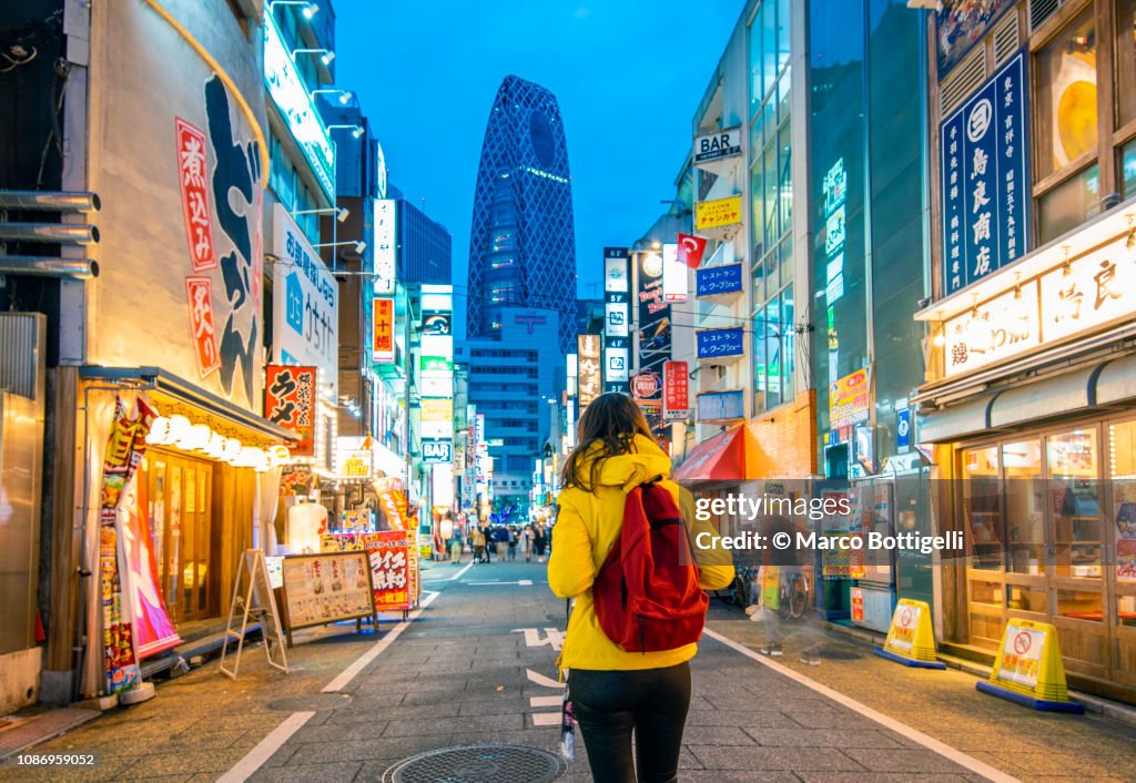Tourist walking in Shinjuku at dusk, Tokyo, Japan