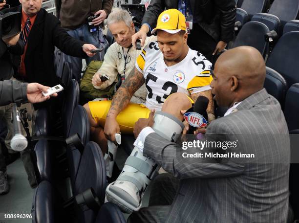 Maurkice Pouncey of the Pittsburgh Steelers shows NFL Network's Deion Sanders his injured left ankle during Super Bowl XLV Media Day ahead of Super...