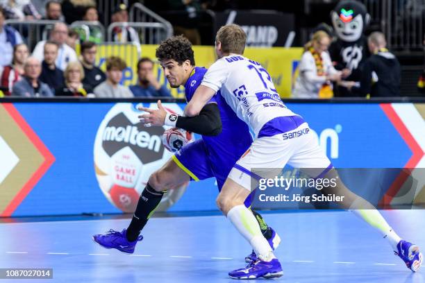 Jose Toledo is challenged by Olafur Andres Gudmundsson during the Main Group 1 match at the 26th IHF Men's World Championship between Brazil and...