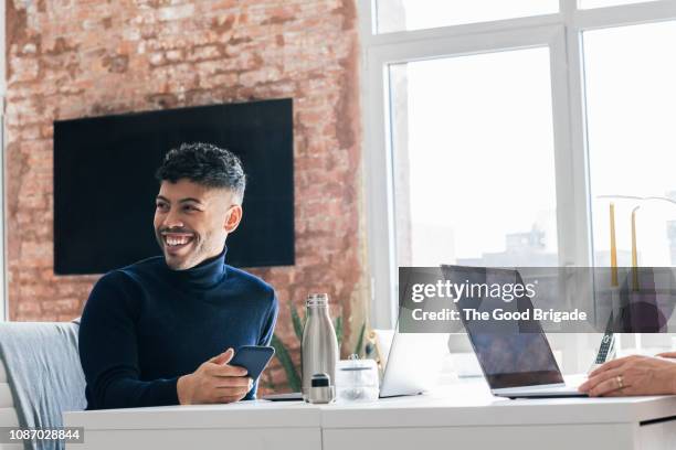 smiling businessman looking over shoulder - gay man stock pictures, royalty-free photos & images