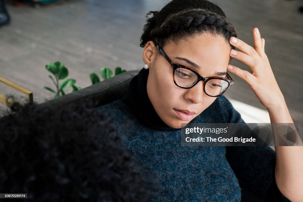 Woman sitting on sofa looking down