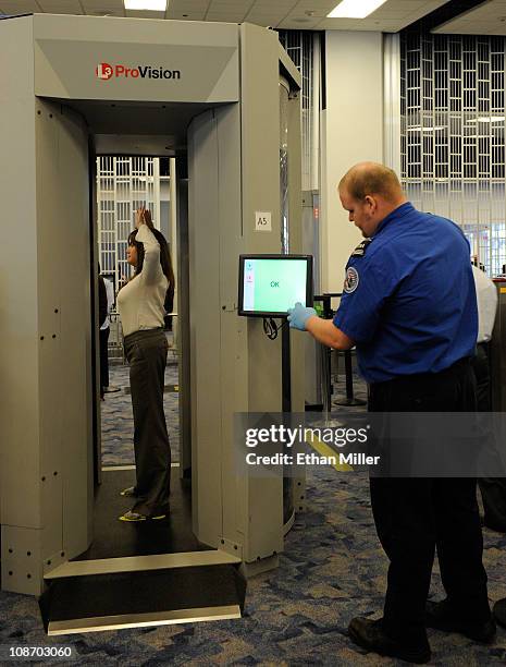 Transportation Security Administration supervisor Nick Fox and another TSA employee demonstrate an advanced image technology millimeter wave scanner...