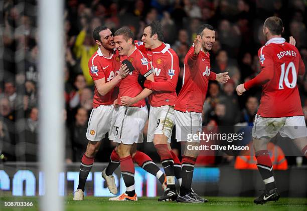 Nemanja Vidic of Manchester United celebrates with his team mates after scoring his team's third goal during the Barclays Premier League match...