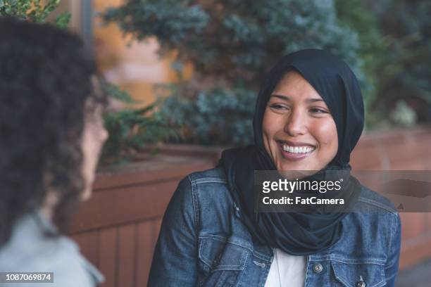 two young women of middle eastern descent talking in the city - stereotypical stock pictures, royalty-free photos & images
