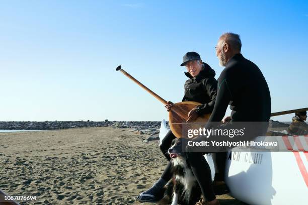 ocean fliends sitting on canoe and talking togather. - surf dog competition stock pictures, royalty-free photos & images