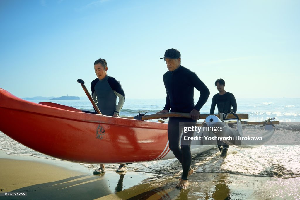 Men playing canoe at Pacific Ocean.