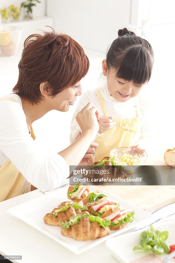 Mother and daughter making sandwiches