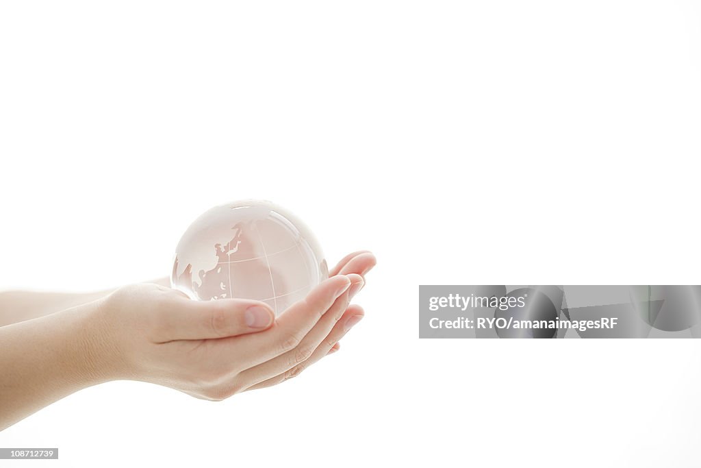 Hand holding glass globe